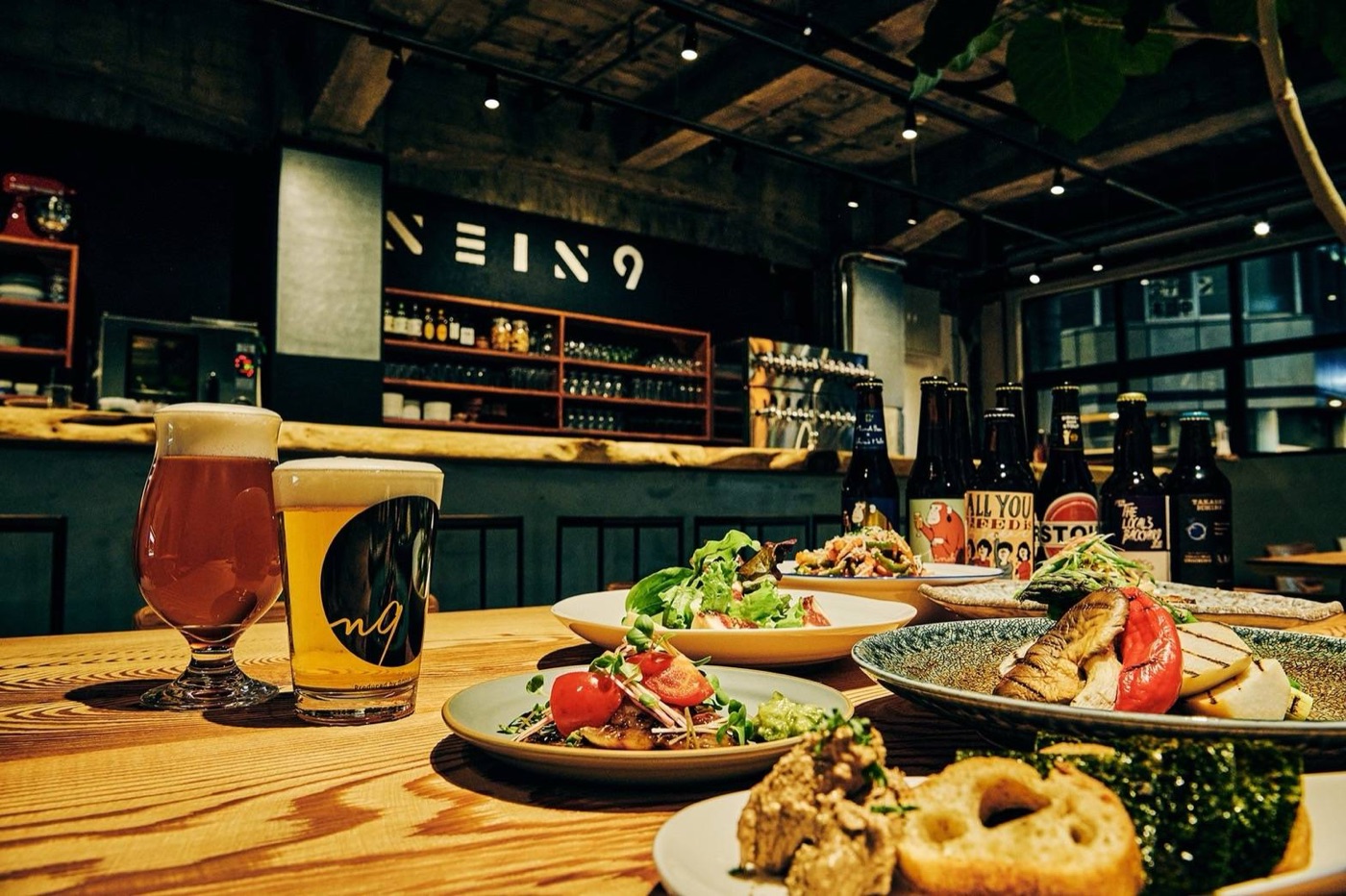 nein9 の樽生クラフトビールと料理が並ぶ卓
